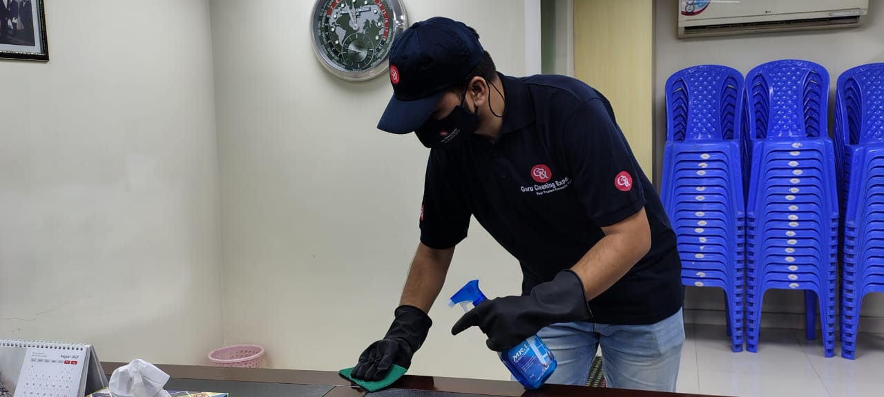 Guru Cleaning Experts team member wiping surfaces for a move-in clean.