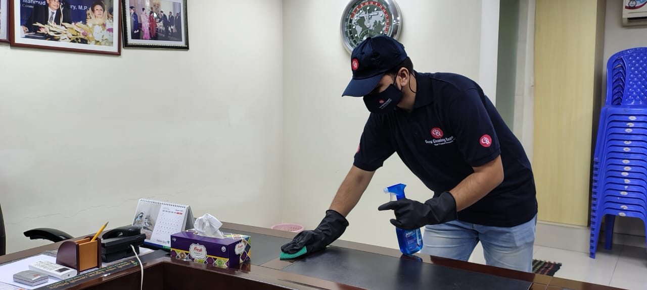 person with a pink glove and spray bottle.